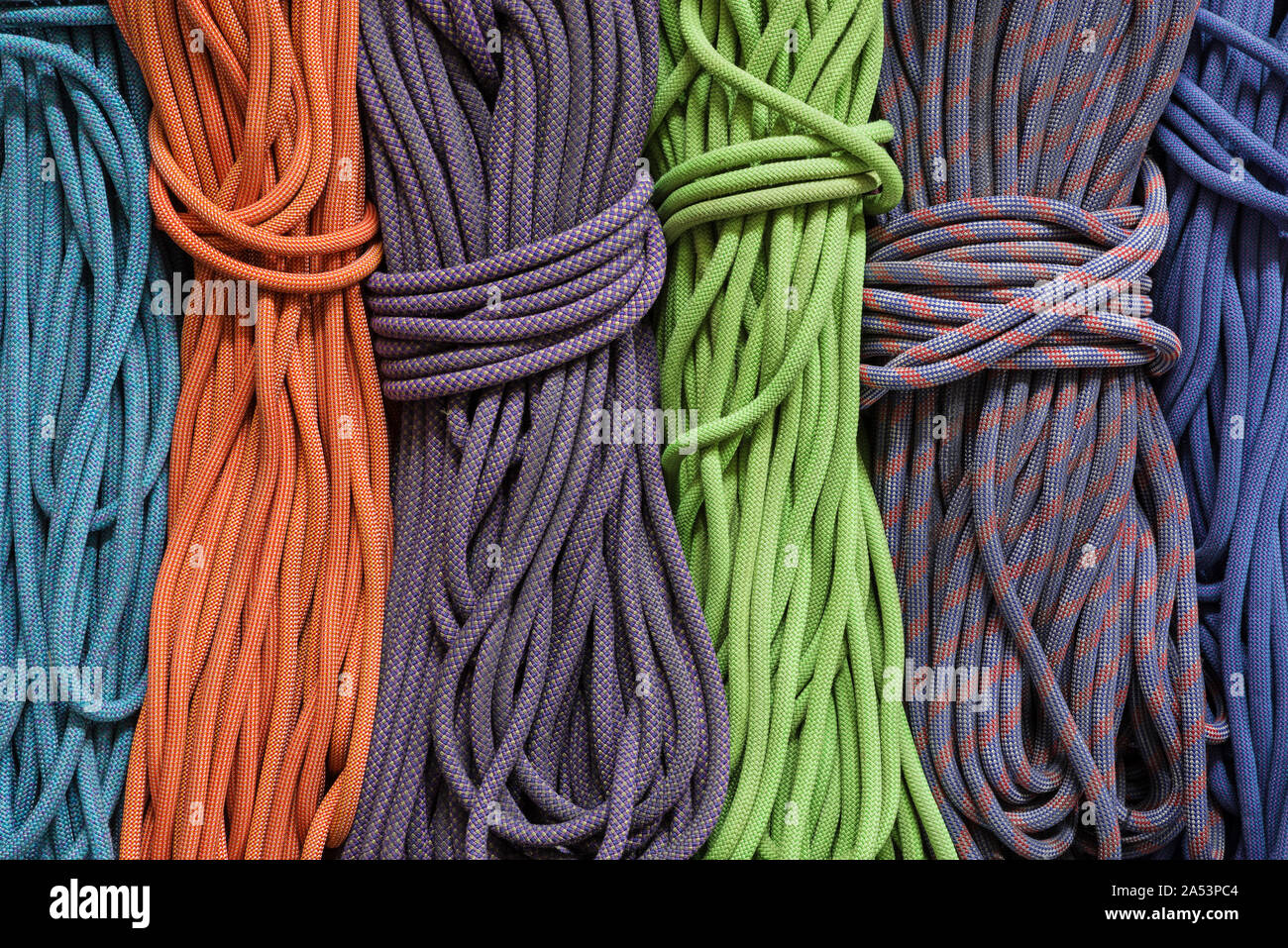 many differently colored coiled up rock climbing ropes Stock Photo