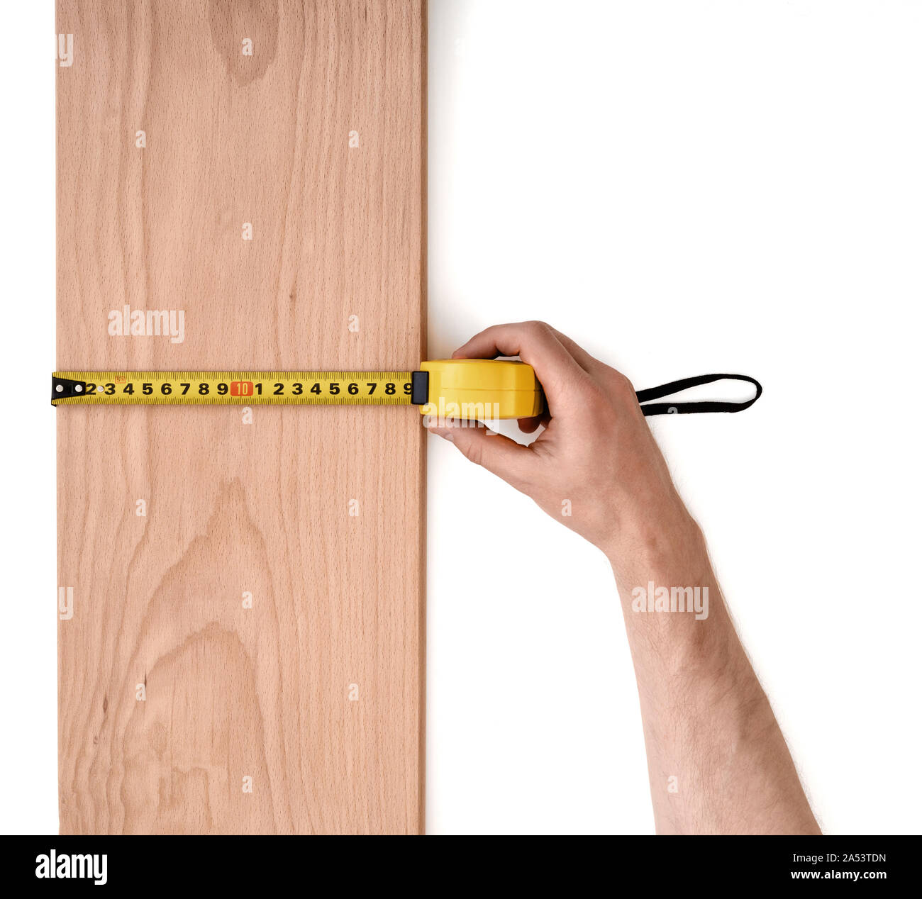 Man's hand measuring wooden plank with a tape line isolated on white