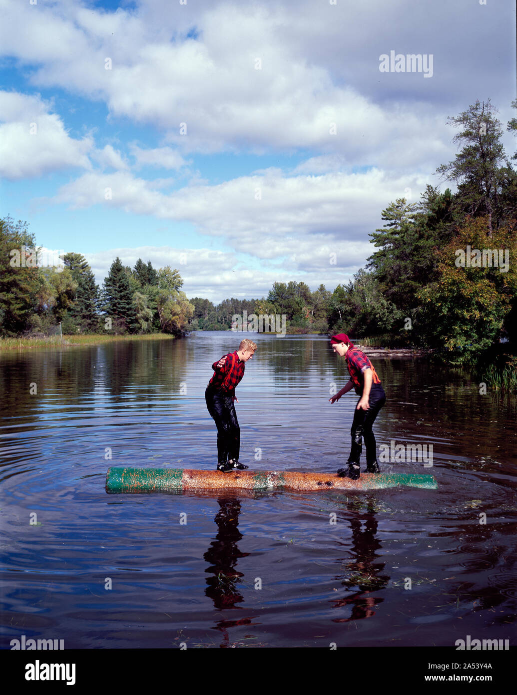 Two young lumberjacks ride a log in the Namekagon River Stock Photo - Alamy