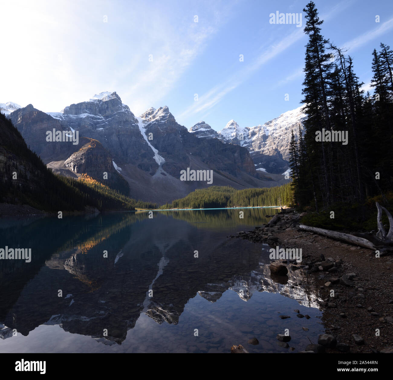 Conifers and mountains are reflected in the glacial waters of Moraine Lake. Moraine Lake, Banff National Park, Alberta, Canada. Stock Photo