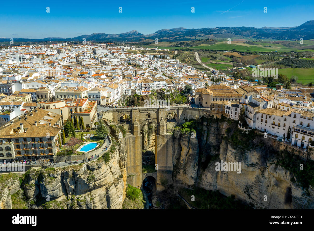 Ronda Spain aerial view of medieval hilltop town surrounded by walls and towers with famous bridge over gorge Stock Photo