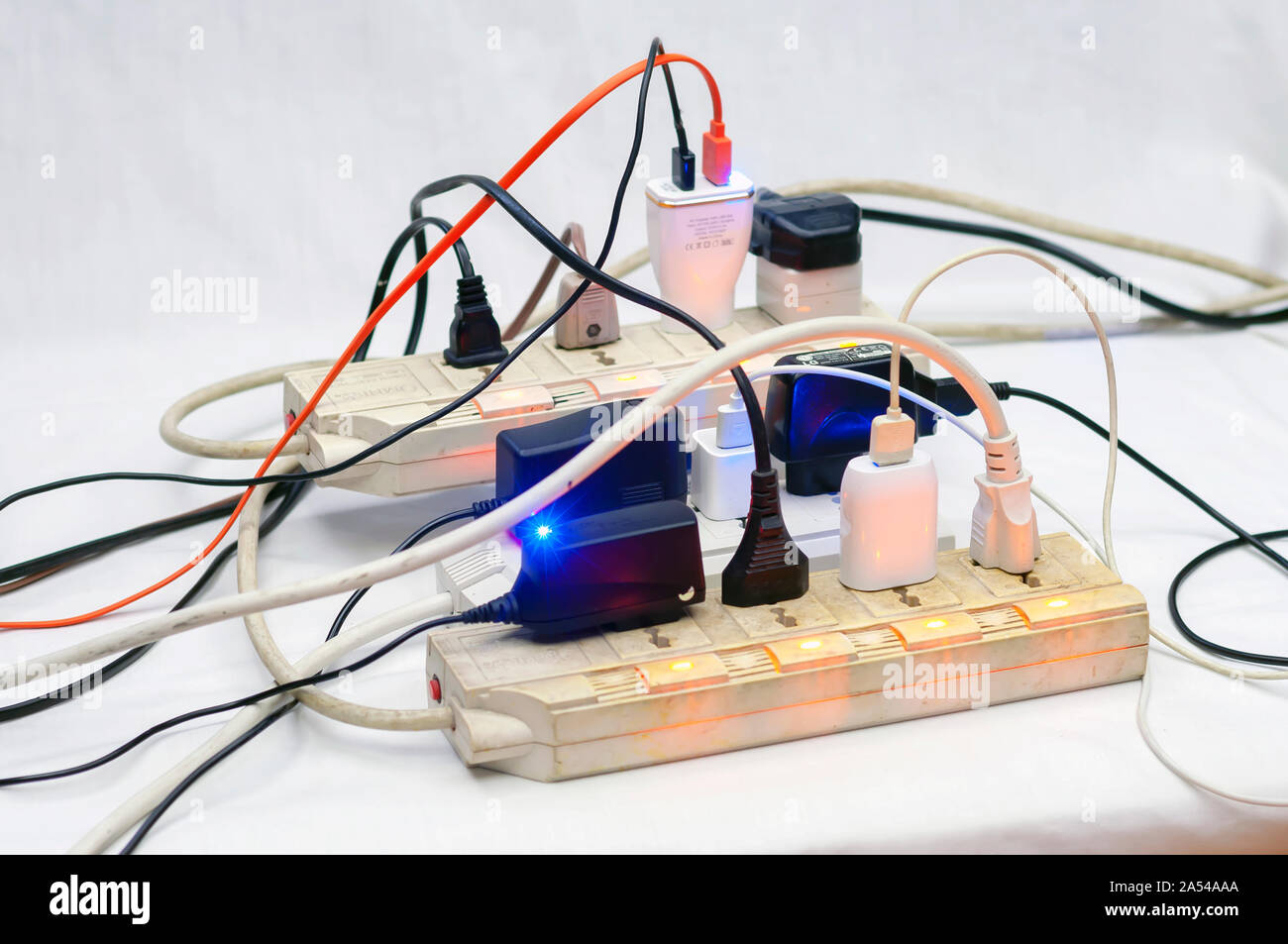 Multiple Overloaded power boards, Full socket extension cord. White isolated background Stock
