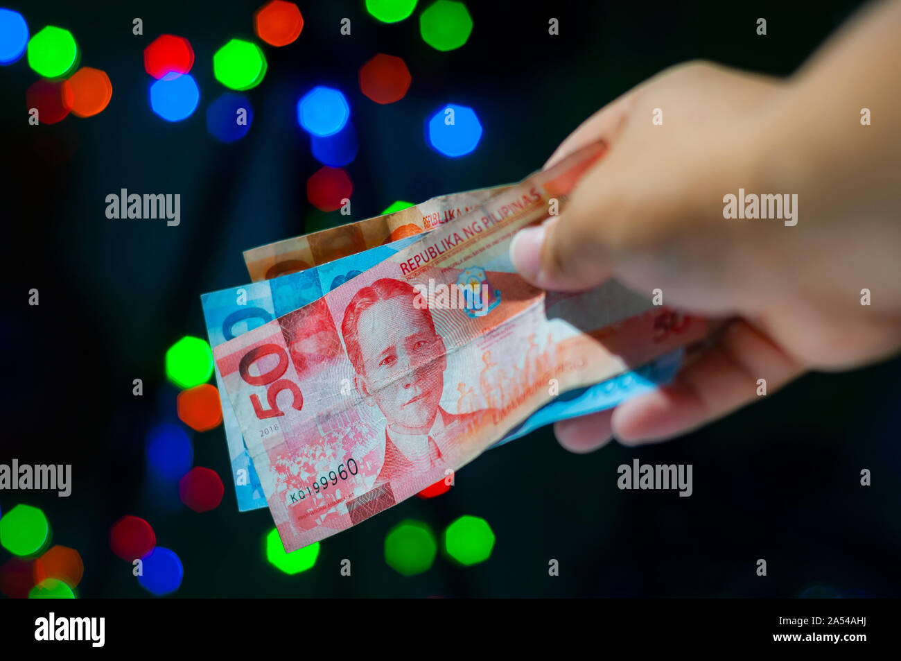 Giving monetary gift in Christmas. Handing out cash as a gift for Holiday. Filipino tradition called Pamasko. Stock Photo