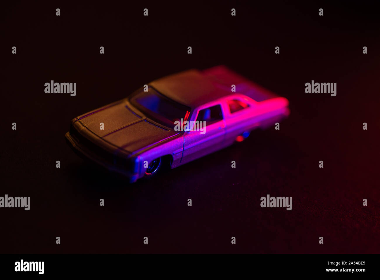 A toy car under red and blue lights, dark background. Stock Photo