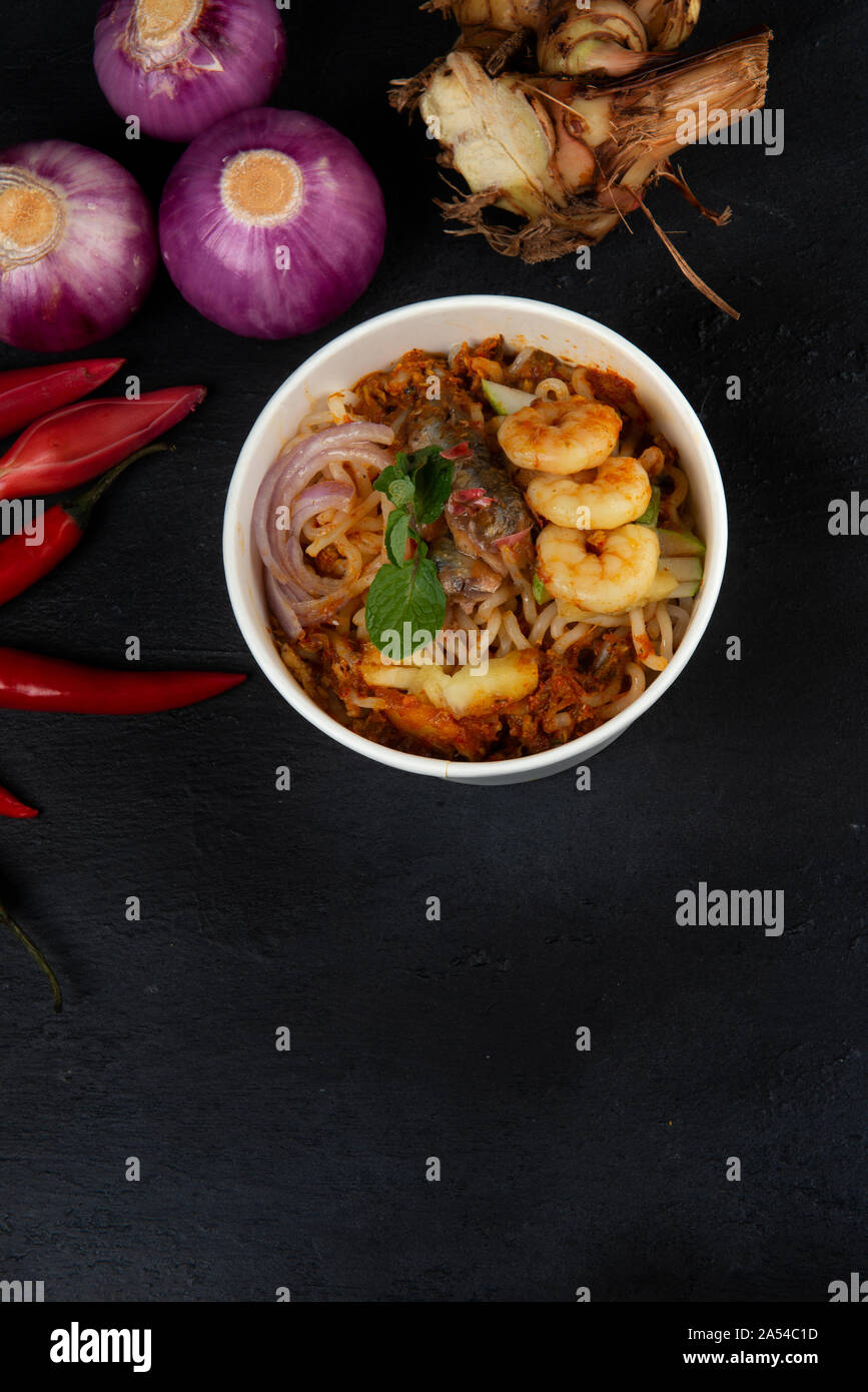 Penang Laksa Noodle Soup flat lay with ingredients on a black table Stock Photo