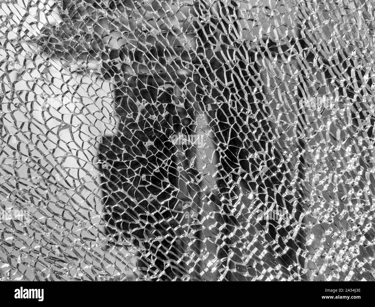 Broken glass background with a web pattern with the city in the background. Destruction, security, armored, shard, vandalism. Stock Photo