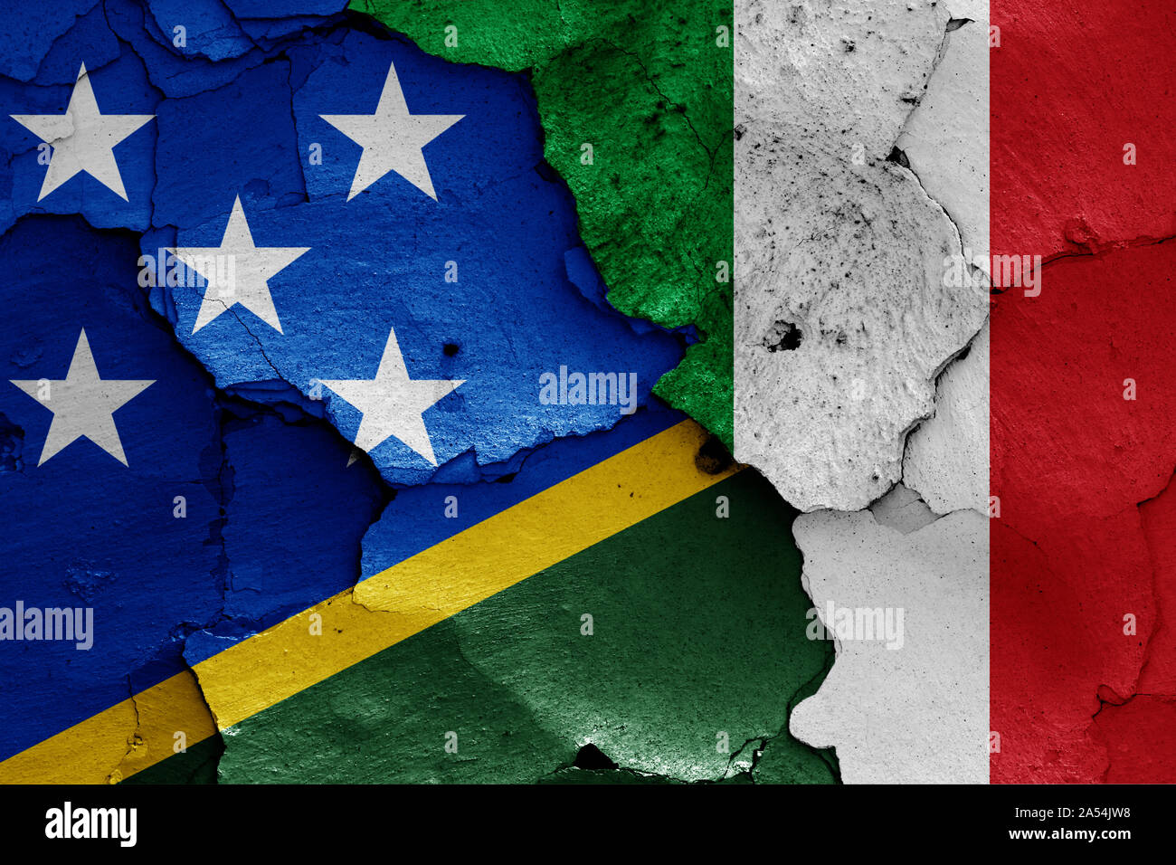 flags of Solomon Islands and Italy painted on cracked wall Stock Photo