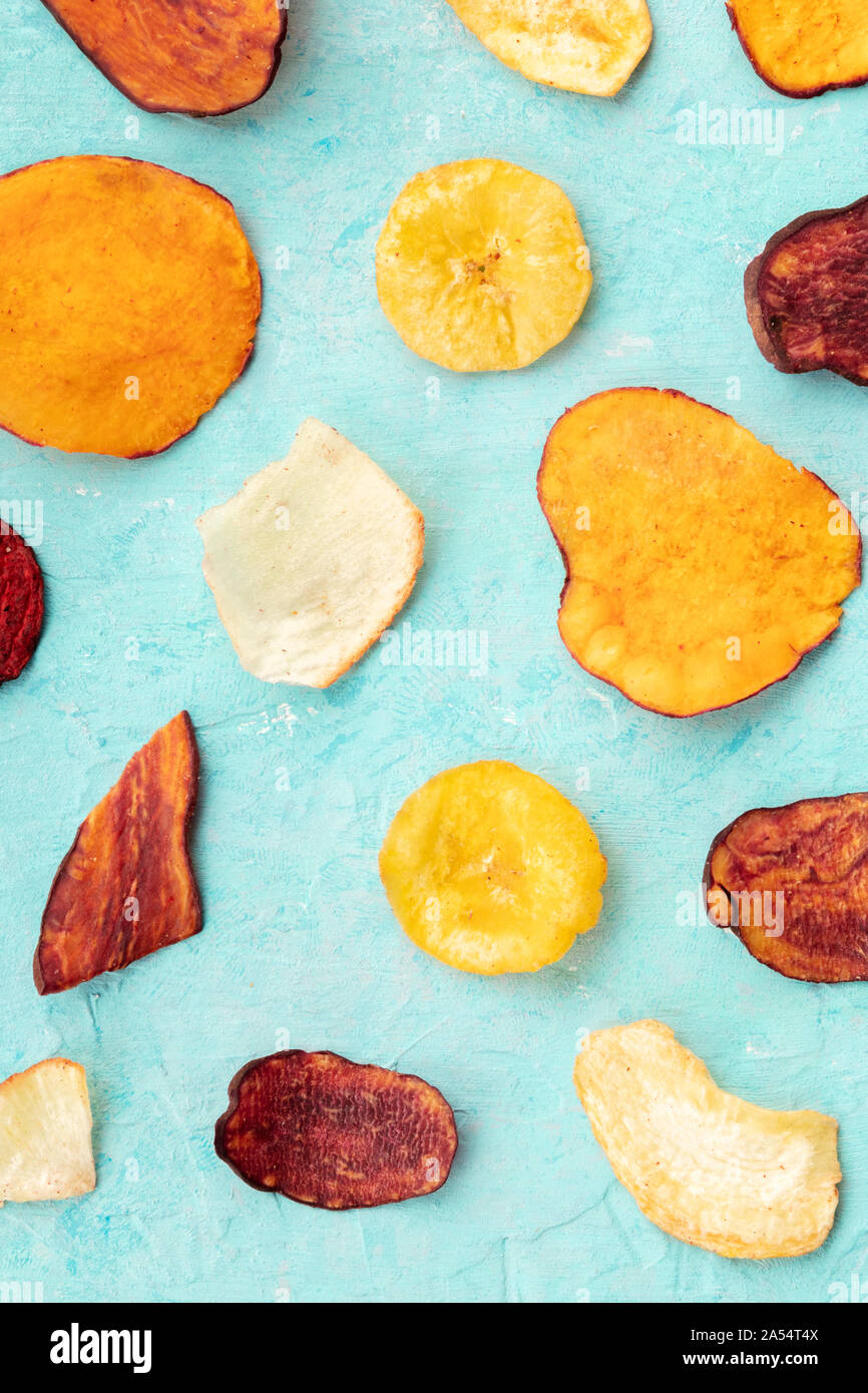 Dried fruit and vegetable chips, shot from above. Healthy vegan snack, an organic food flat lay pattern on a blue background Stock Photo