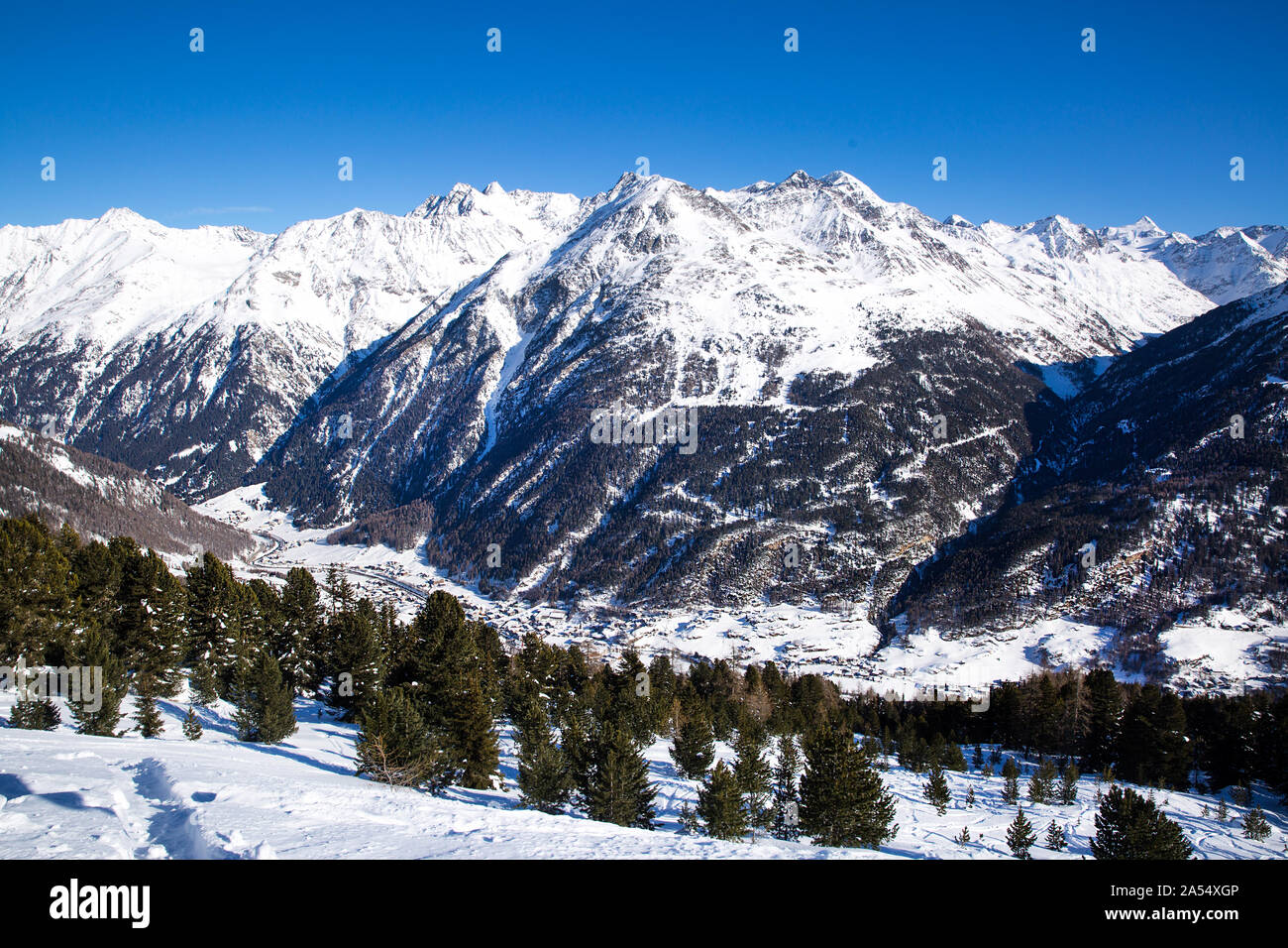 Beautiful Alps in winter and ski village in the valley. Sunny winter day in Tirol, Austria. Ski season. Stock Photo