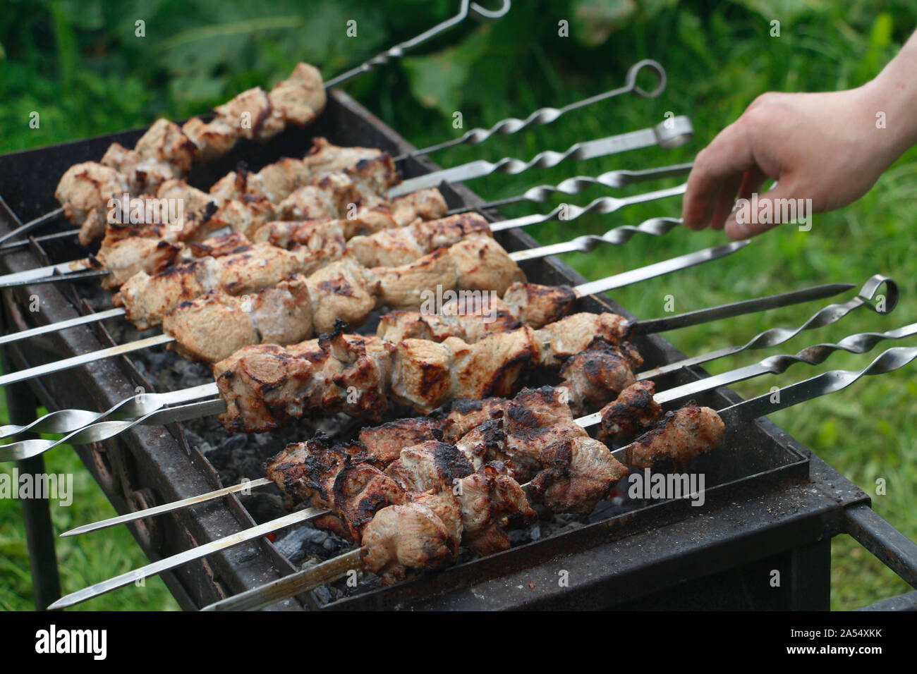 Cook cooks barbecue skewers. Marinated kebab is grilled on charcoal
