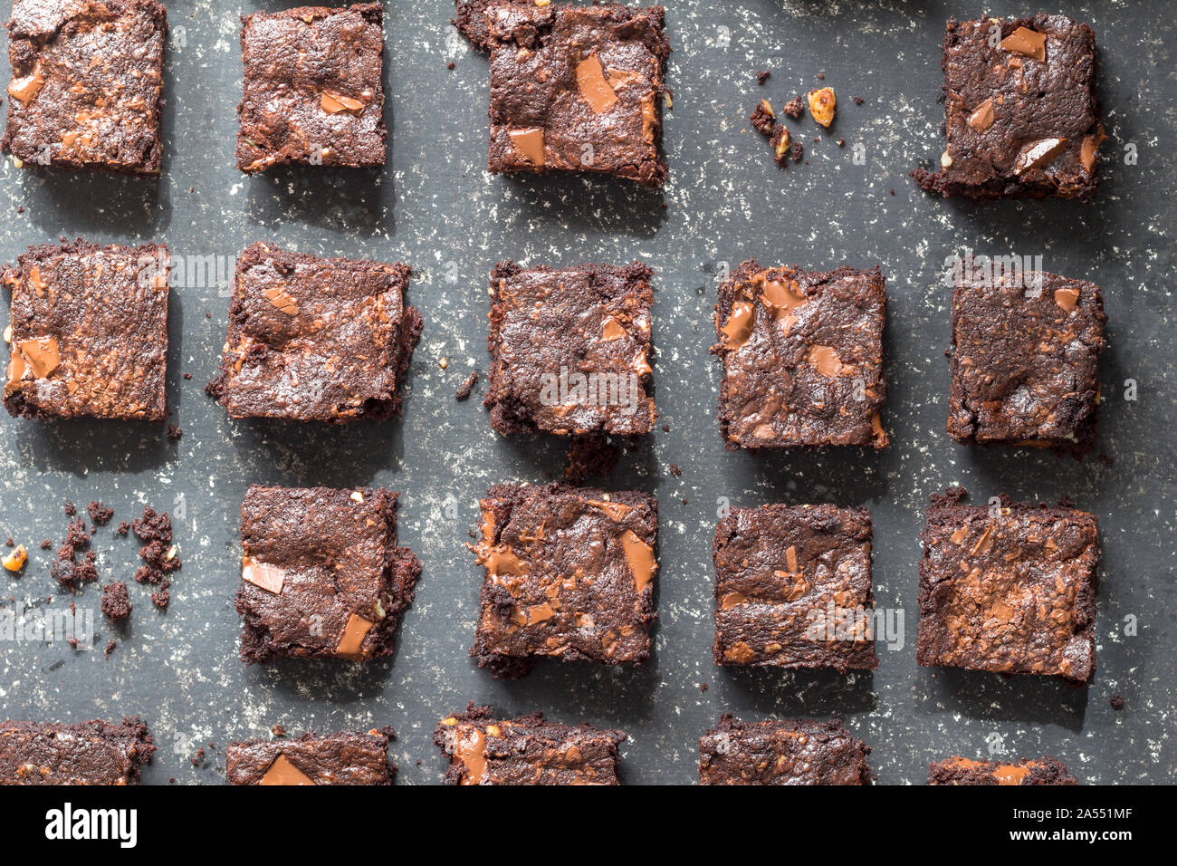 Chocolate brownie cake squares on black mottled texture background - top view photo Stock Photo
