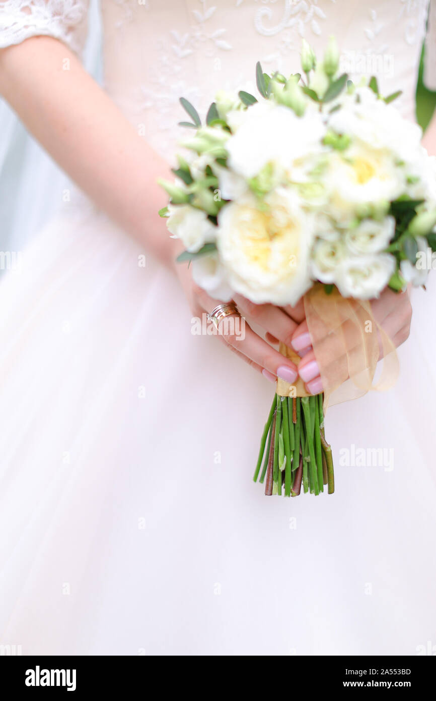 Closeup bride keeping white bouquet. Stock Photo