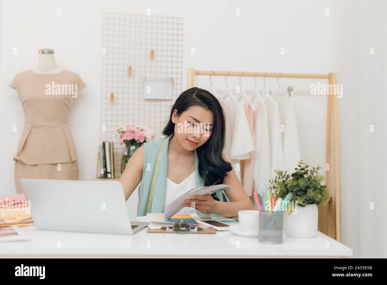 Young Asian fashion designer choosing color for her new collection Stock Photo