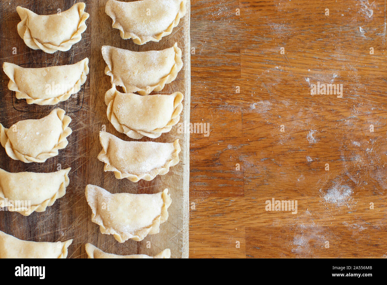 Raw meat pelmeni, ravioli, dumplings top view on a wooden board Stock Photo