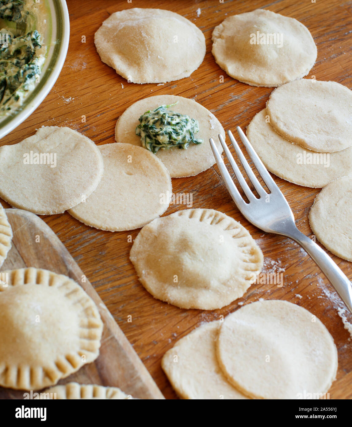 Making ravioli with ricotta cheese and spinach on a wooden board Stock Photo