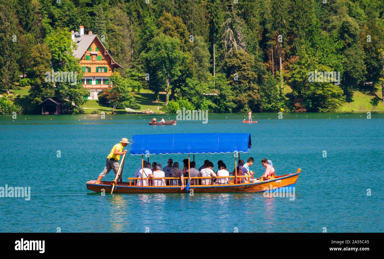 Traditional Wooden pletna boat with tourists  on Lake Bled  in Upper Carniola, Slovenia Stock Photo