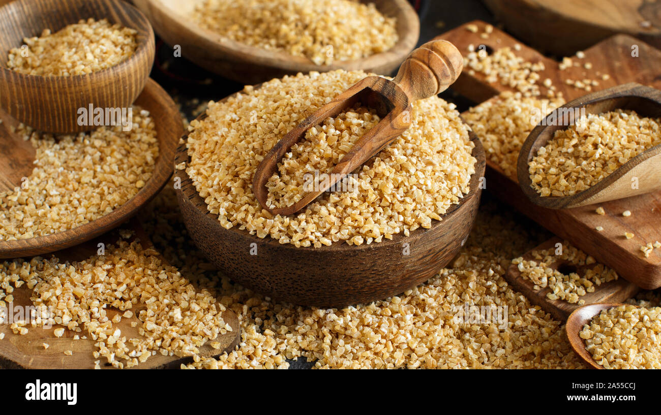 Dry bulgur wheat grains in bowls close up Stock Photo