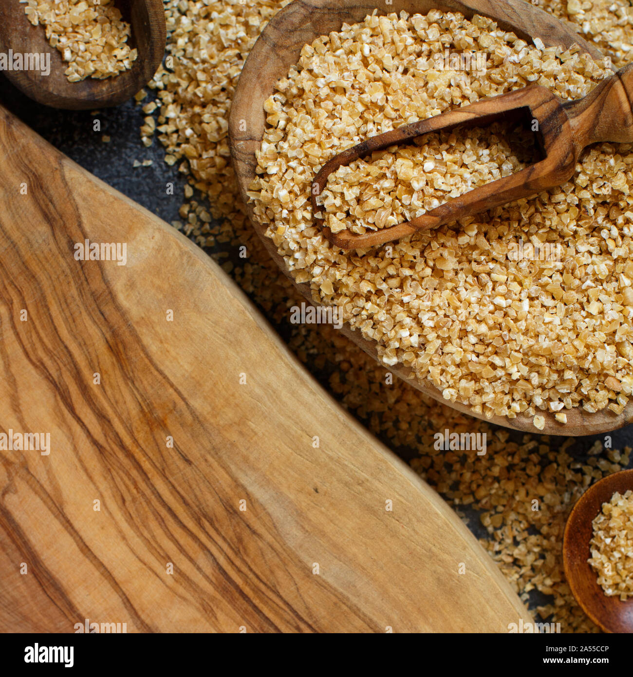 Dry bulgur wheat grains in bowls close up Stock Photo