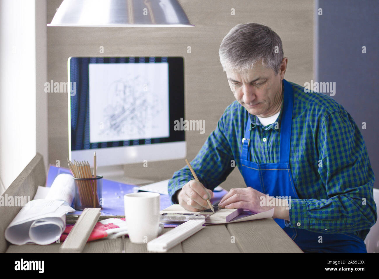 Engineer carpenter working on laptop and sketching project Stock Photo ...