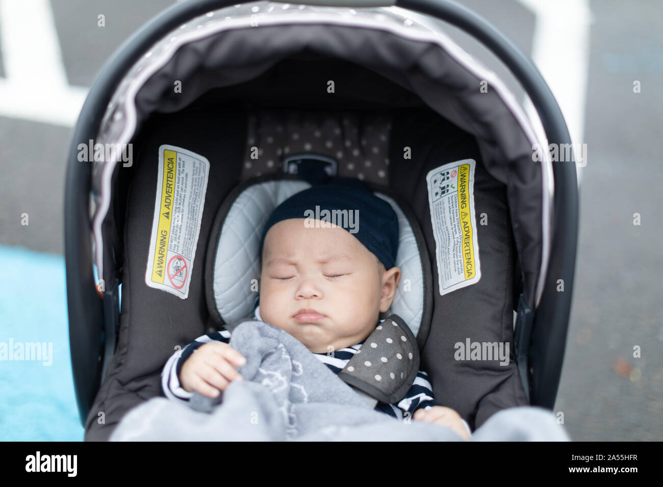 Cute sleeping baby in child car seat going for a family road trip Stock