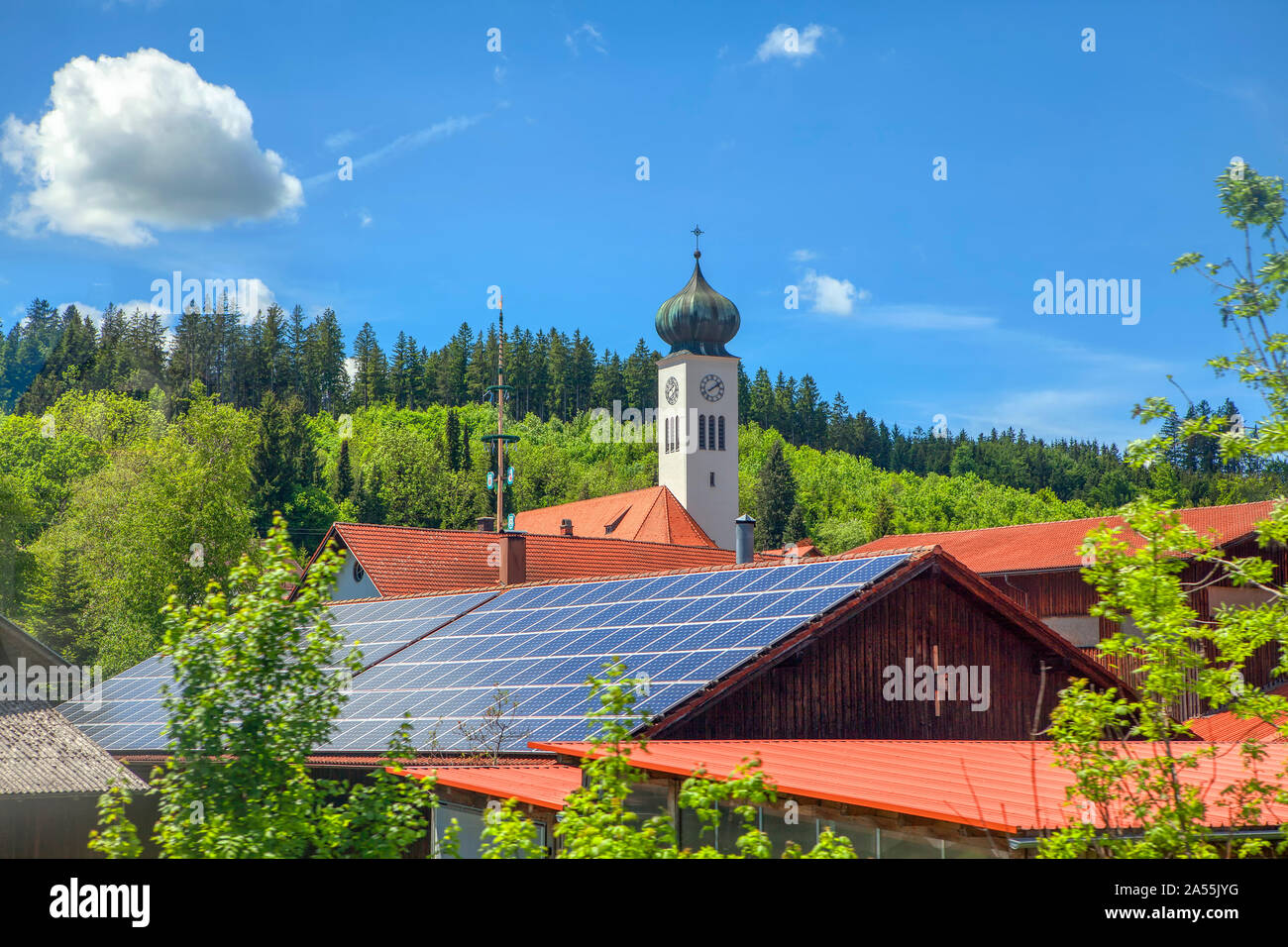 roof with solar batteries and spire with horology Stock Photo
