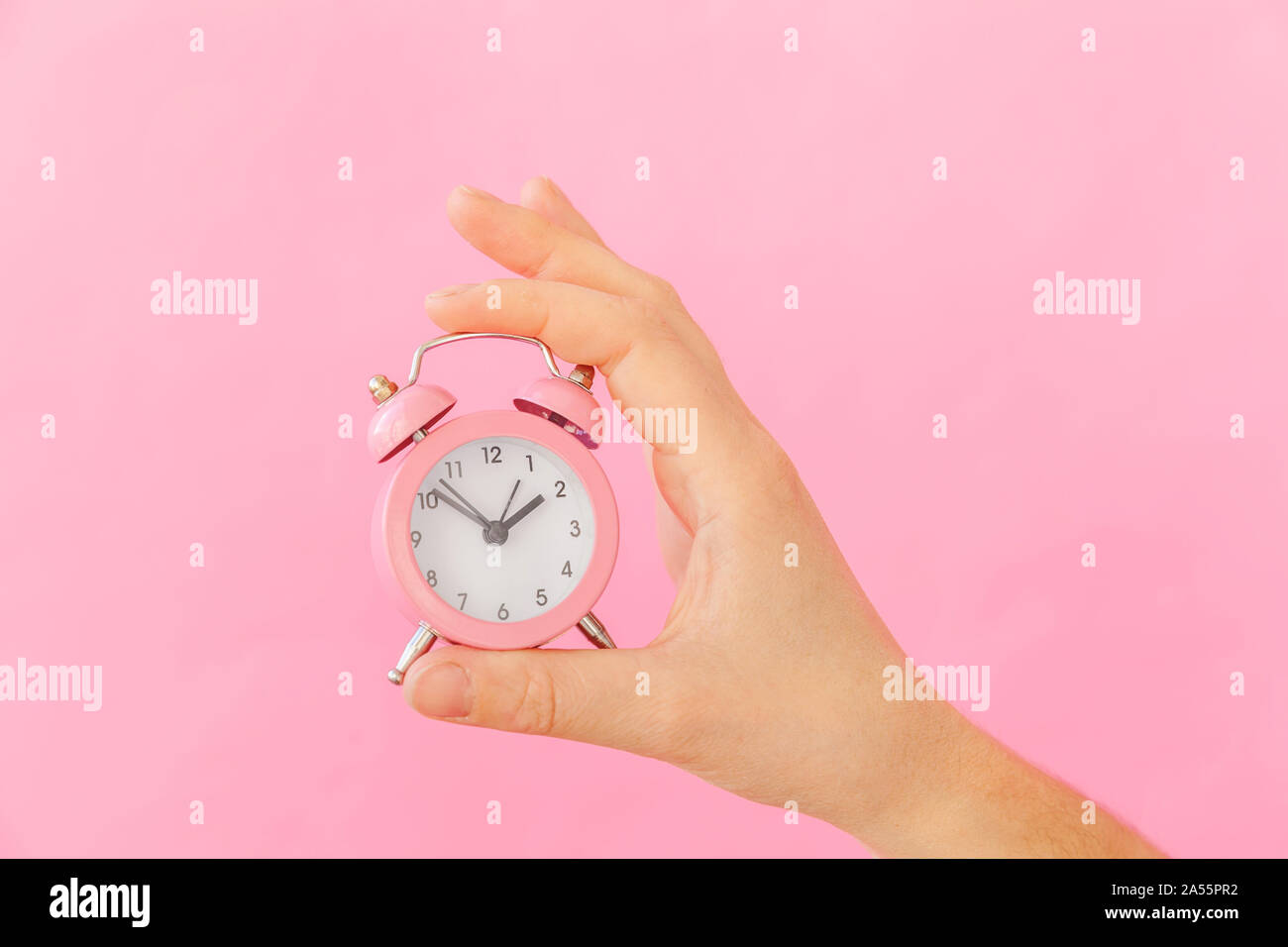 Simply design female woman hand holding ringing twin bell alarm clock ...