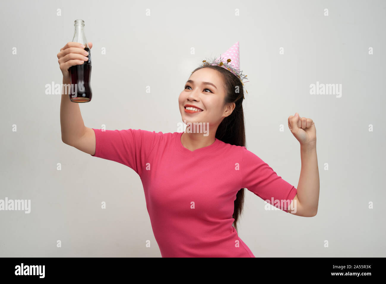 Stylish asian woman drinking soda dancing over white background Stock Photo