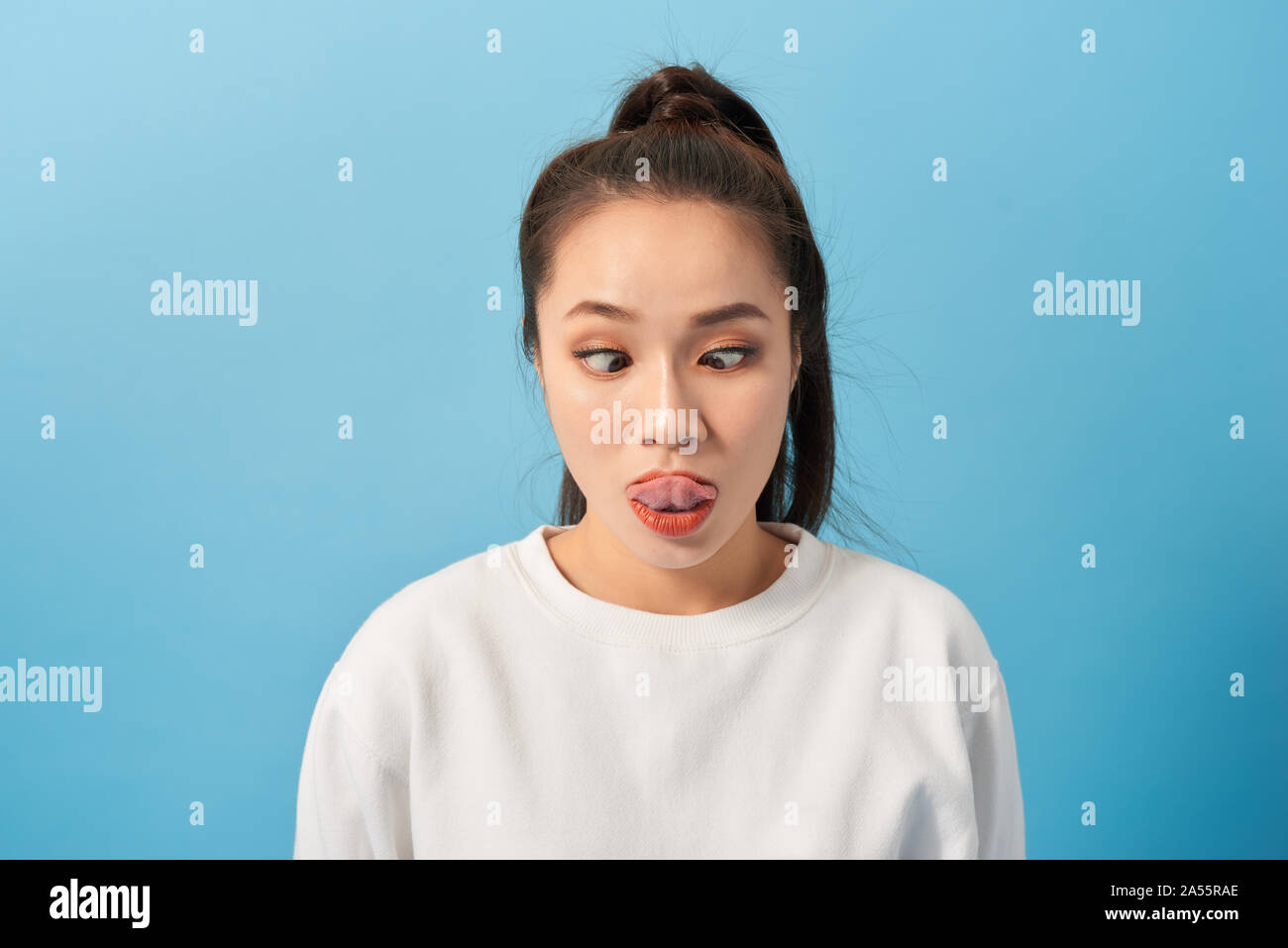 A young woman grimaces at the camera. Funny woman fooling around Stock Photo