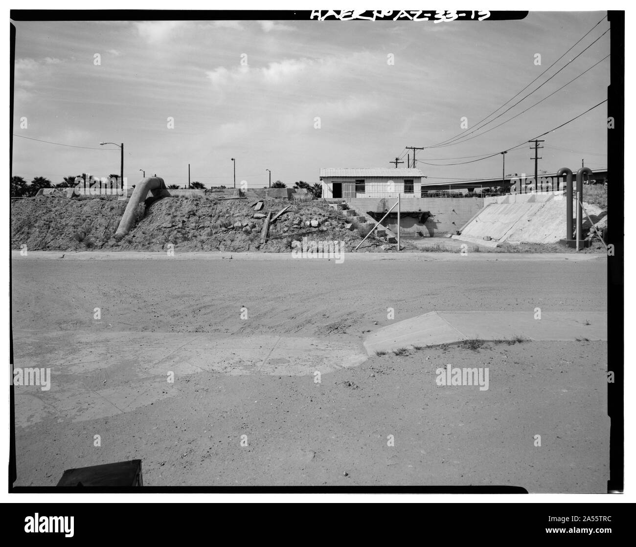 VIEW LOOKING NORTH TOWARD THE SOUTH END OF SETTLING RESERVOIR NO. 1 (LEFT) AND REMNANT OF SETTLING RESERVOIR NO. 2 (RIGHT). THE NONHISTORIC CHEMICAL BUILDING IS SEEN IN THE CENTER BACKGROUND. THE SOUTH WALL AND SOUTH BERM OF RESERVOIR NO. 2 WERE REMOVED CIRCA 1944. JONES STREET IS IN THE FOREGROUND. - Yuma Main Street Water Treatment Plant, Jones Street at foot of Main Street, Yuma, Yuma County, AZ Stock Photo