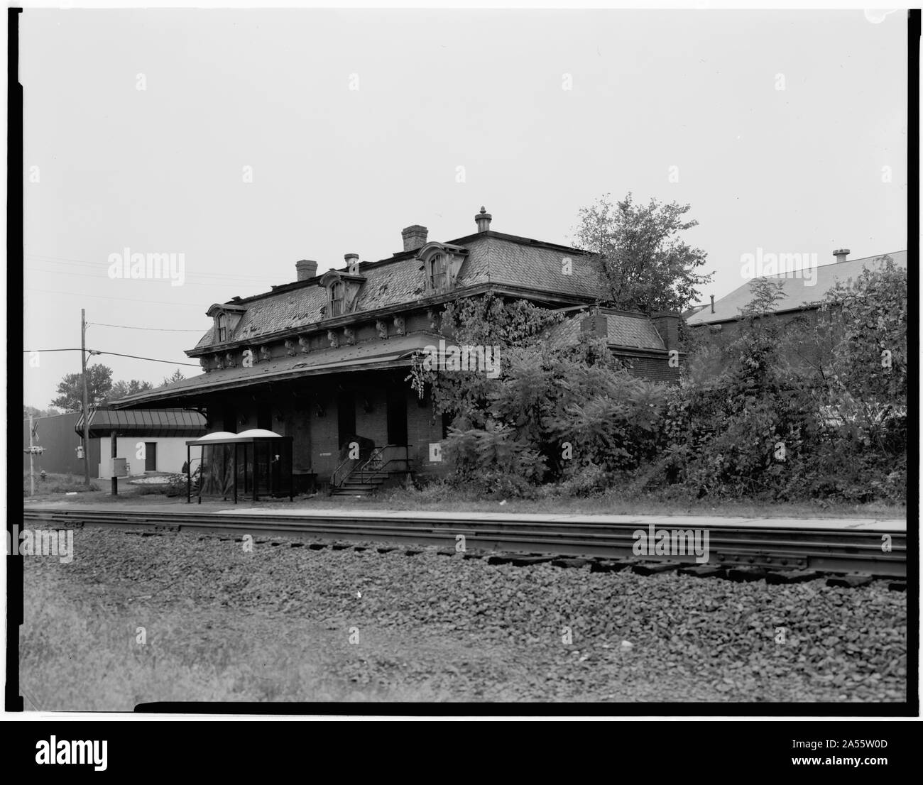 Windsor station in October 1985, three years before being restored. Amtrak passengers used the bus shelter visible next to the station.Original caption:  VIEW, LOOKING SOUTHEAST, NORTH AND EAST SIDE - Hartford & New Haven Railroad, Depot, 35 Central Street, Windsor, Hartford County, CT Stock Photo