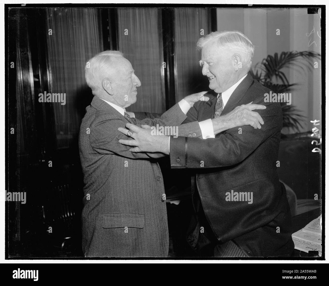 V.P. Garner extends warm hug of congratulations to Demo. Senator Carter Glass of Va. who will be celebrating his 81st birthday, 1/1939 Stock Photo