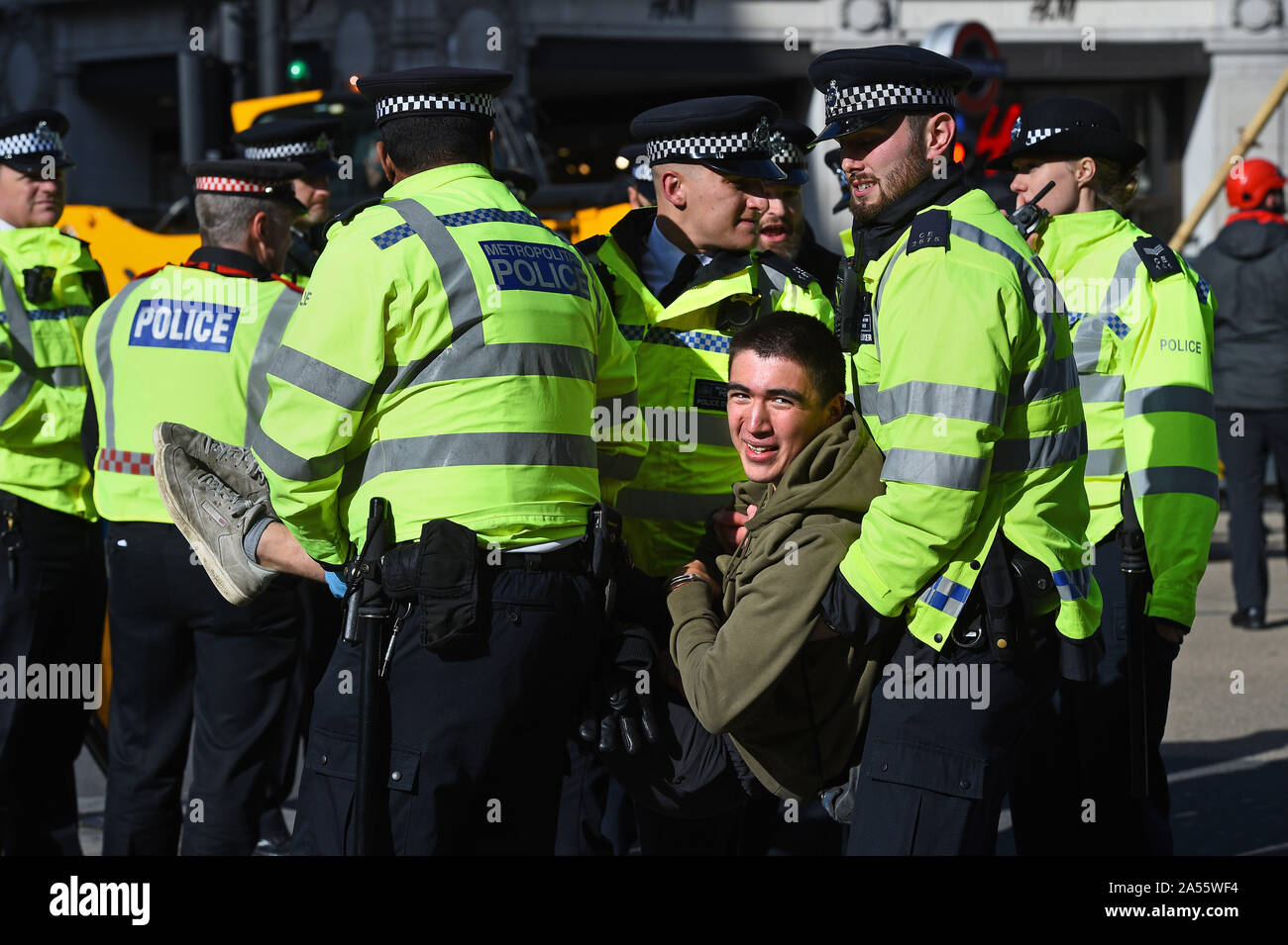 Police remove a protester at Oxford Circus, London, during an ...