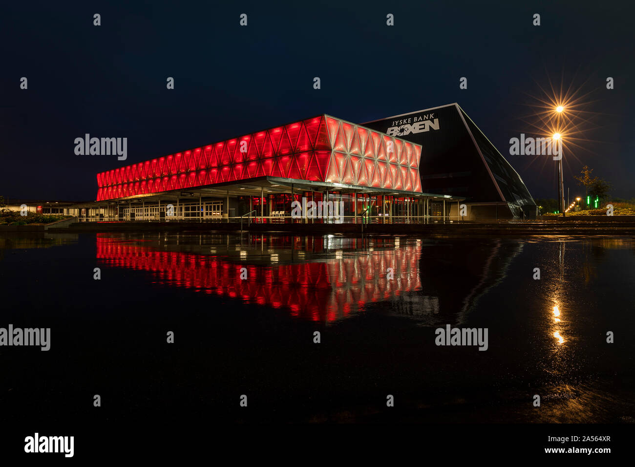 Jyske Bank Boxen, a multi arena located in Herning Denmark. Seen on a rainy night with the red light reflecting in the wet aspalt Stock Photo