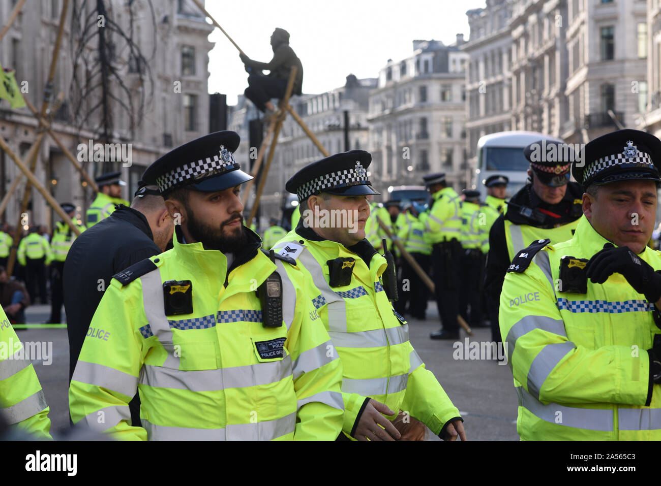 London, UK. 18th Oct, 2019. A crowd of Met Police officers stand in front of climate change activits occupying London’s Oxford Circus. Credit: Kevin Shalvey/Alamy Live News Stock Photo