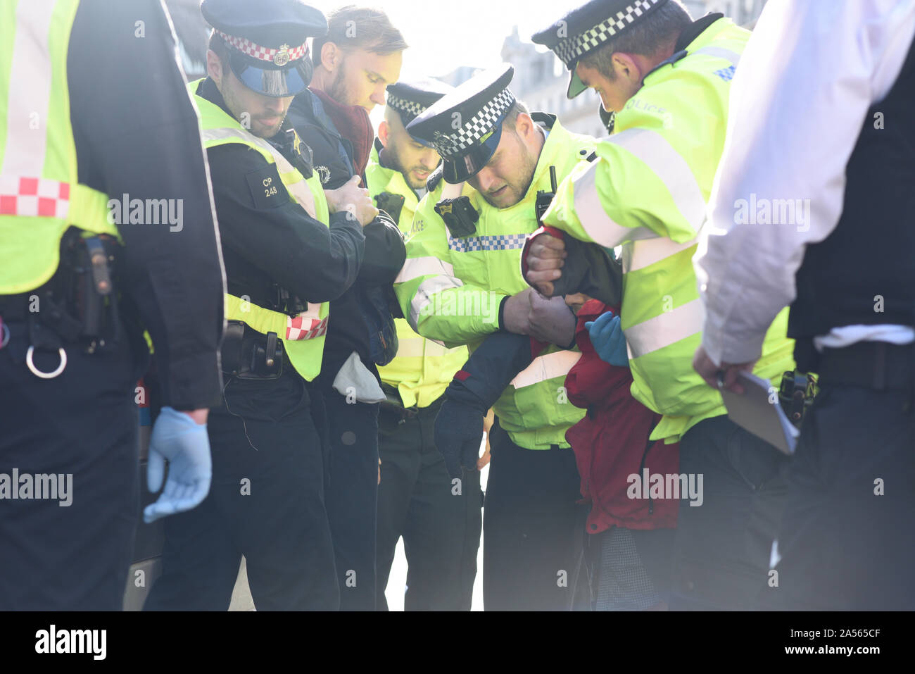 London, UK. 18th Oct, 2019. A crowd of Met Police officers arrest two climate change activits occupying London’s Oxford Circus. Credit: Kevin Shalvey/Alamy Live News Stock Photo