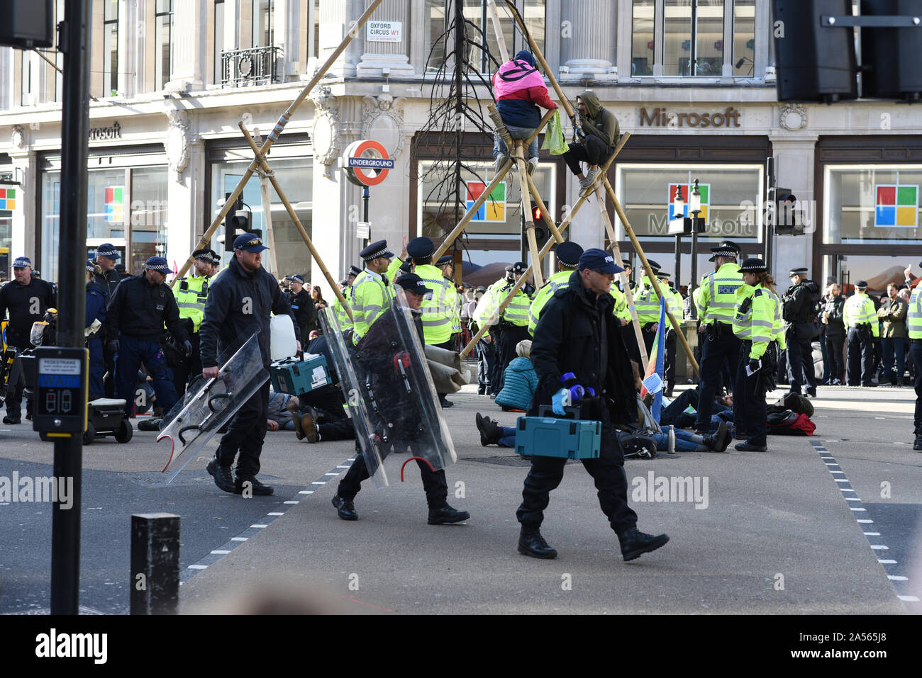 London, UK. 18th Oct, 2019. Police officers carry equipment to dismantle a makeshift structure bult by climate protestors in Oxford Circus. Credit: Kevin Shalvey/Alamy Live News Stock Photo