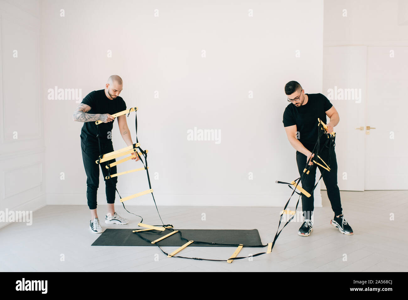 Fitness instructors preparing agility ladder in studio Stock Photo