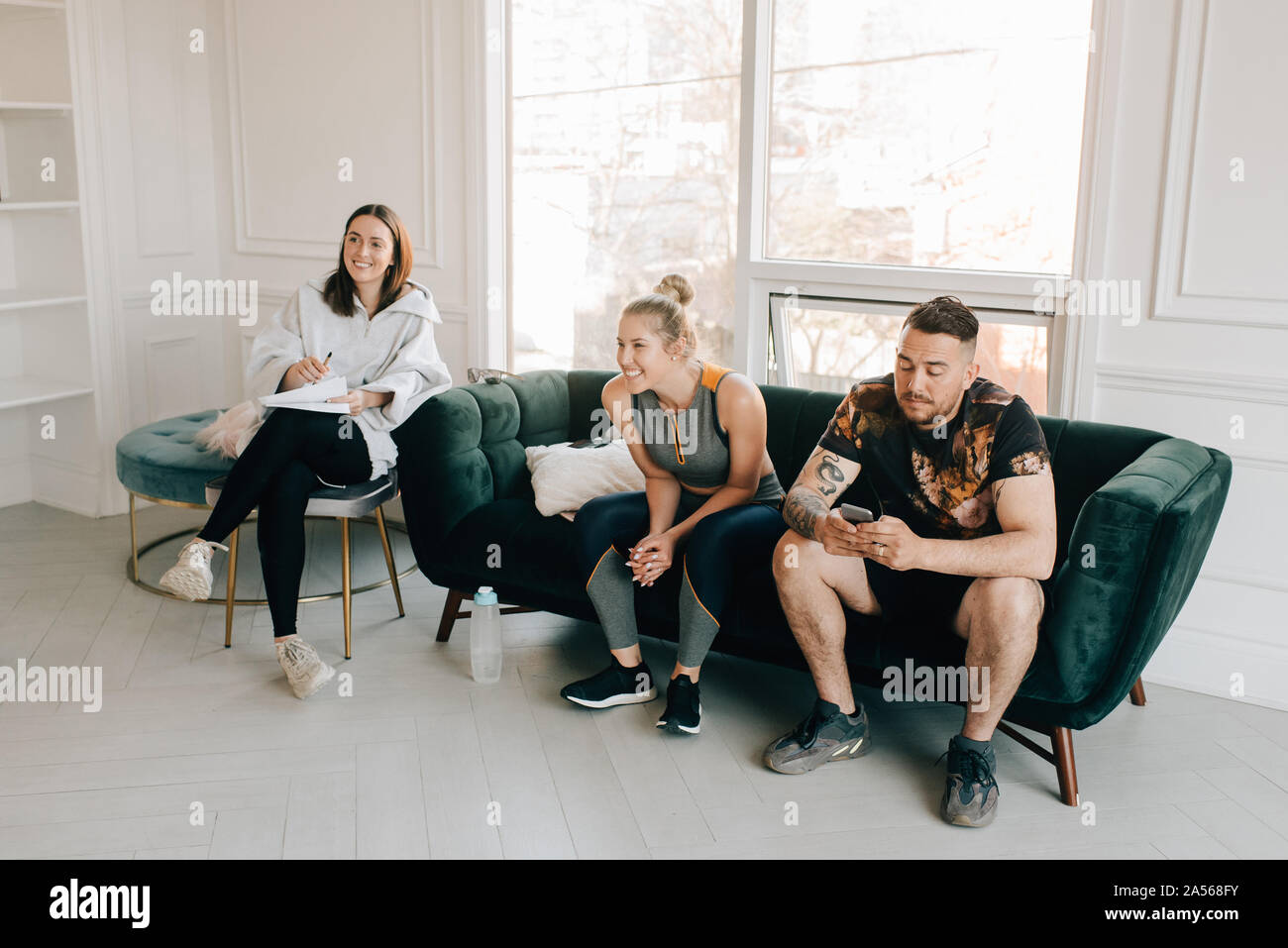 Friends talking and using smartphone in studio Stock Photo