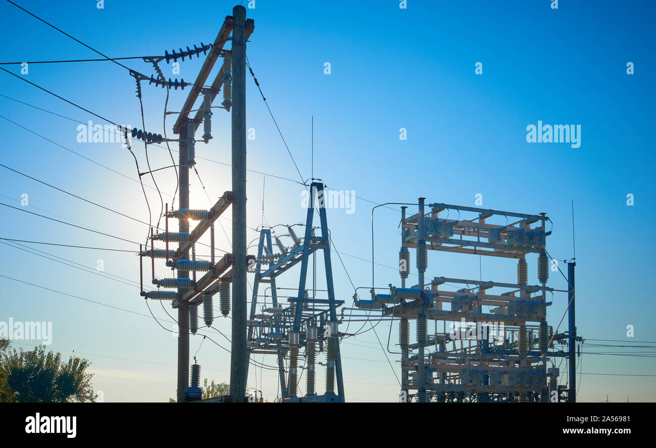 Electric substation with sun behind towers. Stock Photo