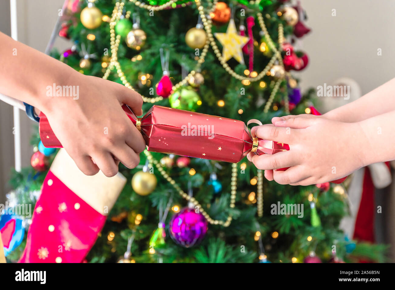 Australian chrildren pull Christmas cracker with lollies, paper hat and
