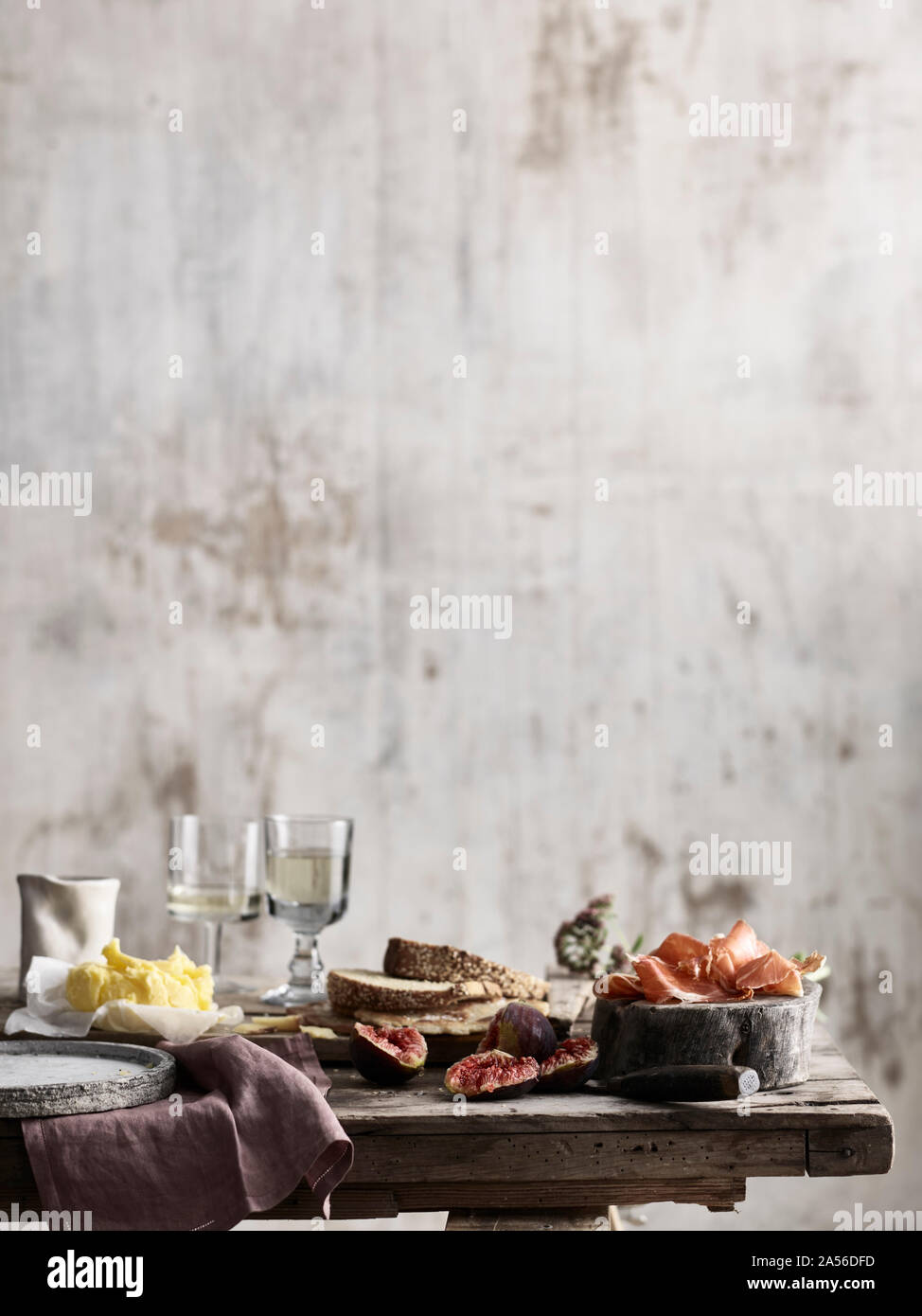 Spread of bread, butter, figs and ham on table Stock Photo