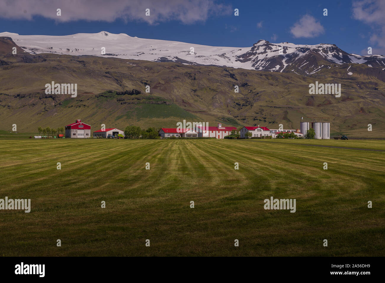 Landscape with distant row of houses and ice cap, Eyjafjallajökull, Iceland Stock Photo