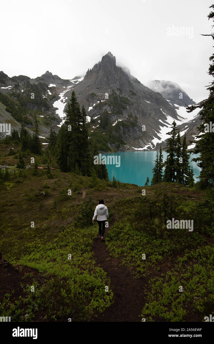 Tourist exploring wilderness, Alpine Blue Lake, Washington, USA Stock Photo