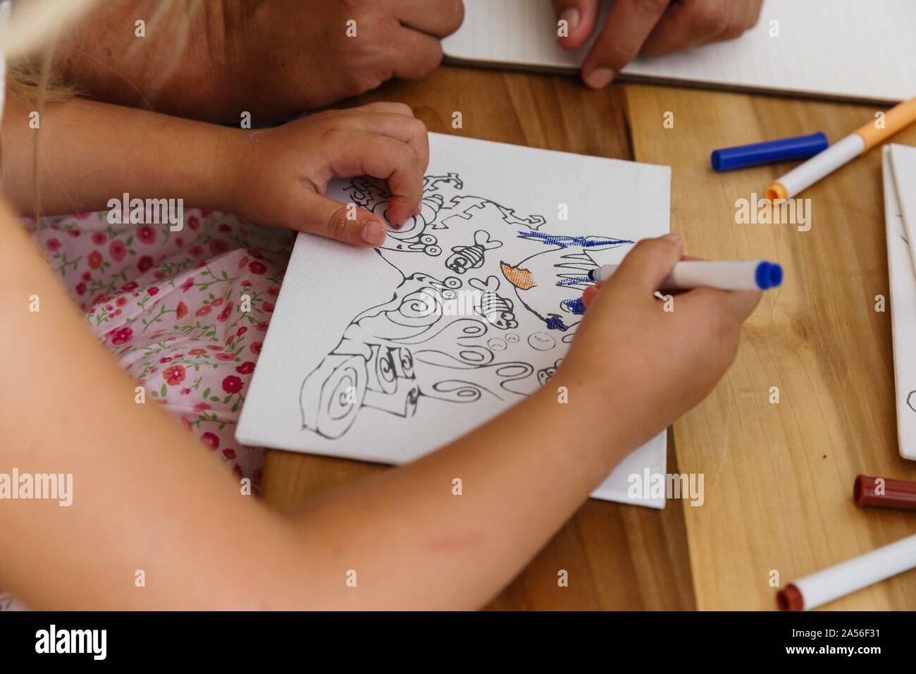 Child colouring a picture on a table Stock Photo