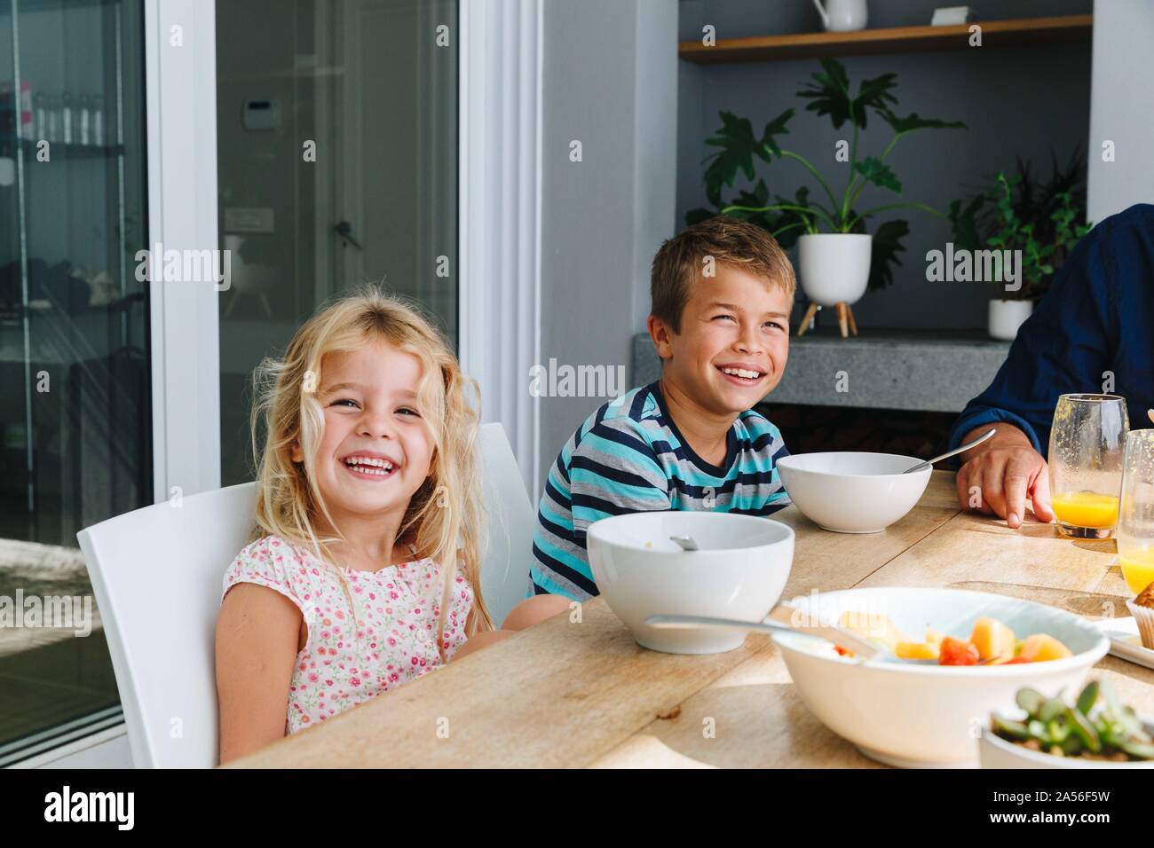 Children having lunch with father at home Stock Photo