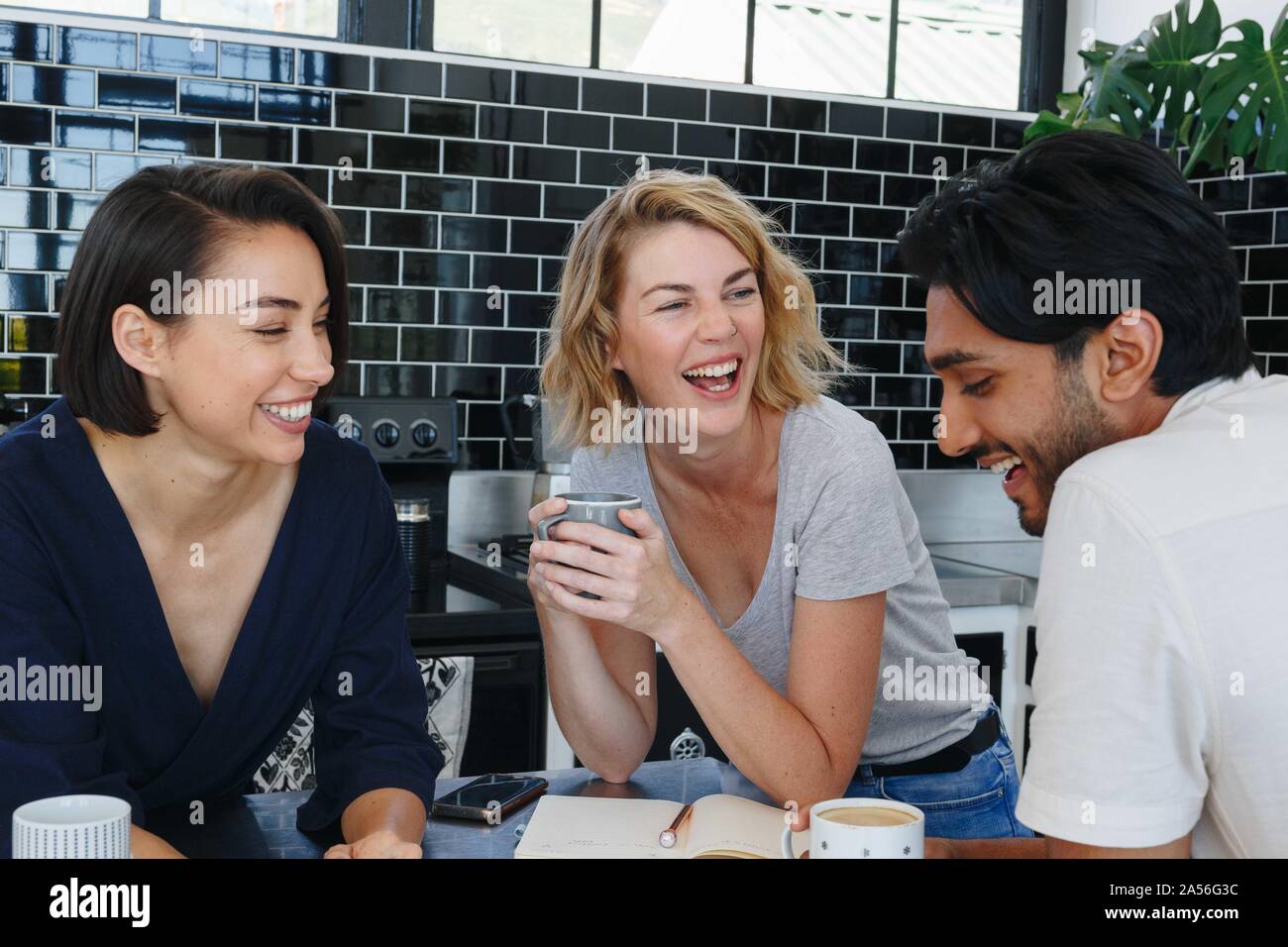 Colleagues talking and working at coffee break in pantry Stock Photo