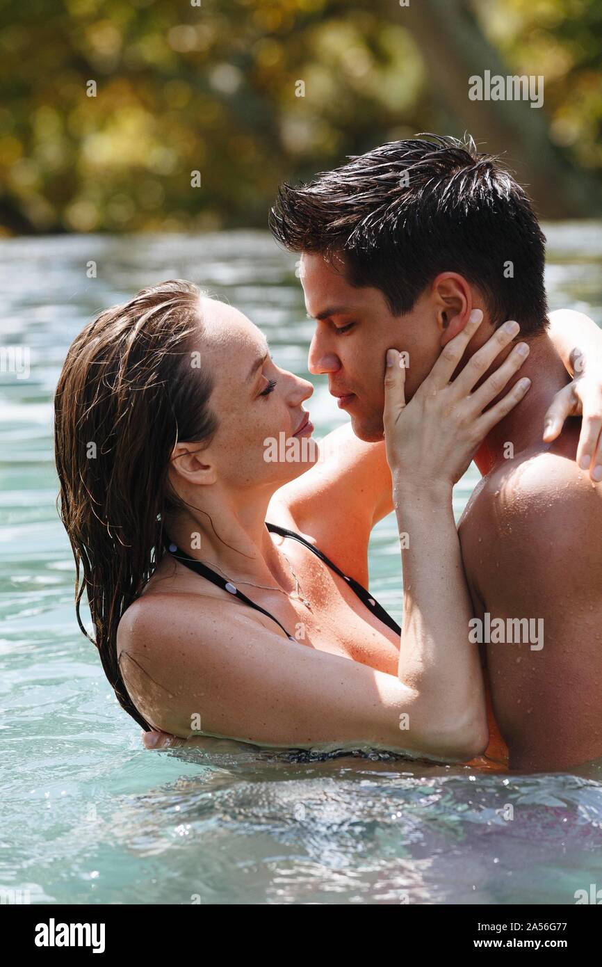 Couple kissing in swimming pool Stock Photo