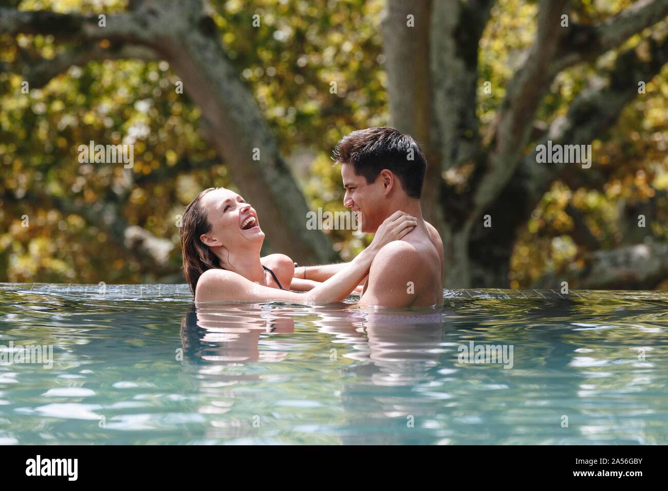 Couple laughing in swimming pool Stock Photo