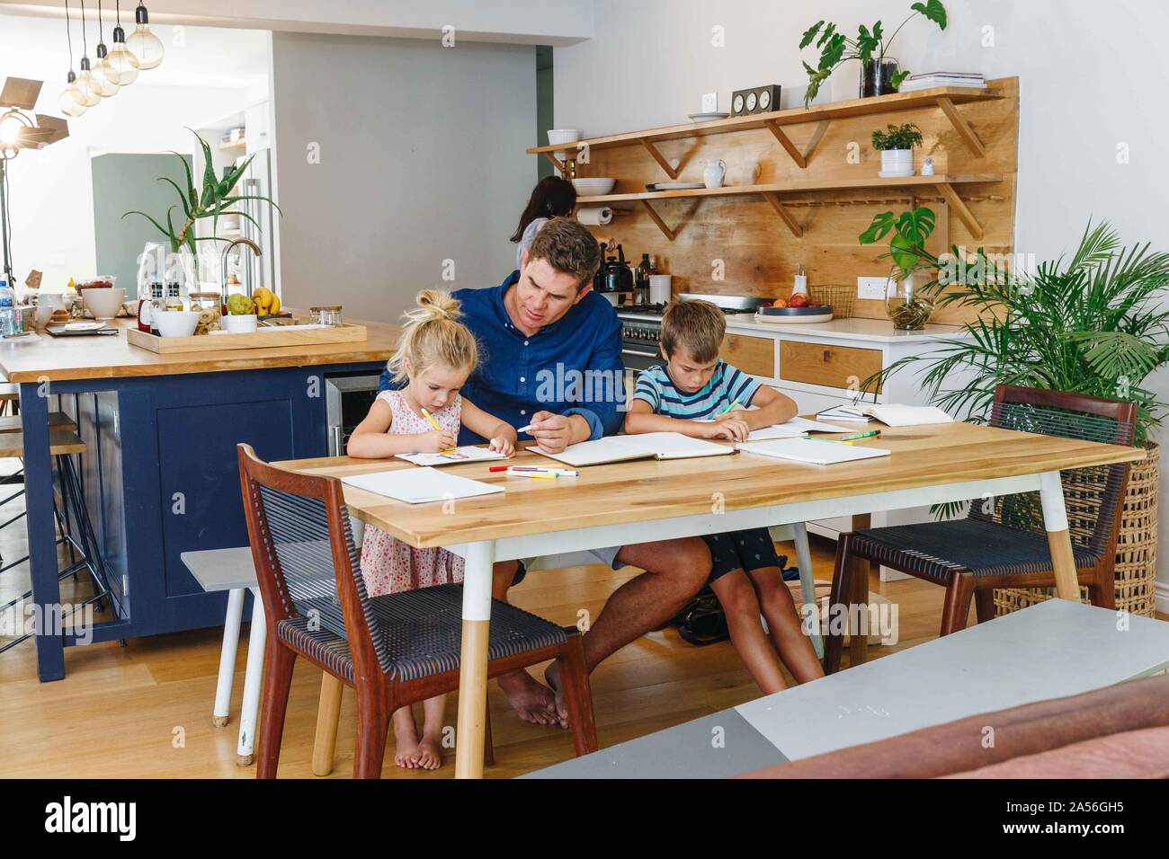 Father helping children with homework at home Stock Photo