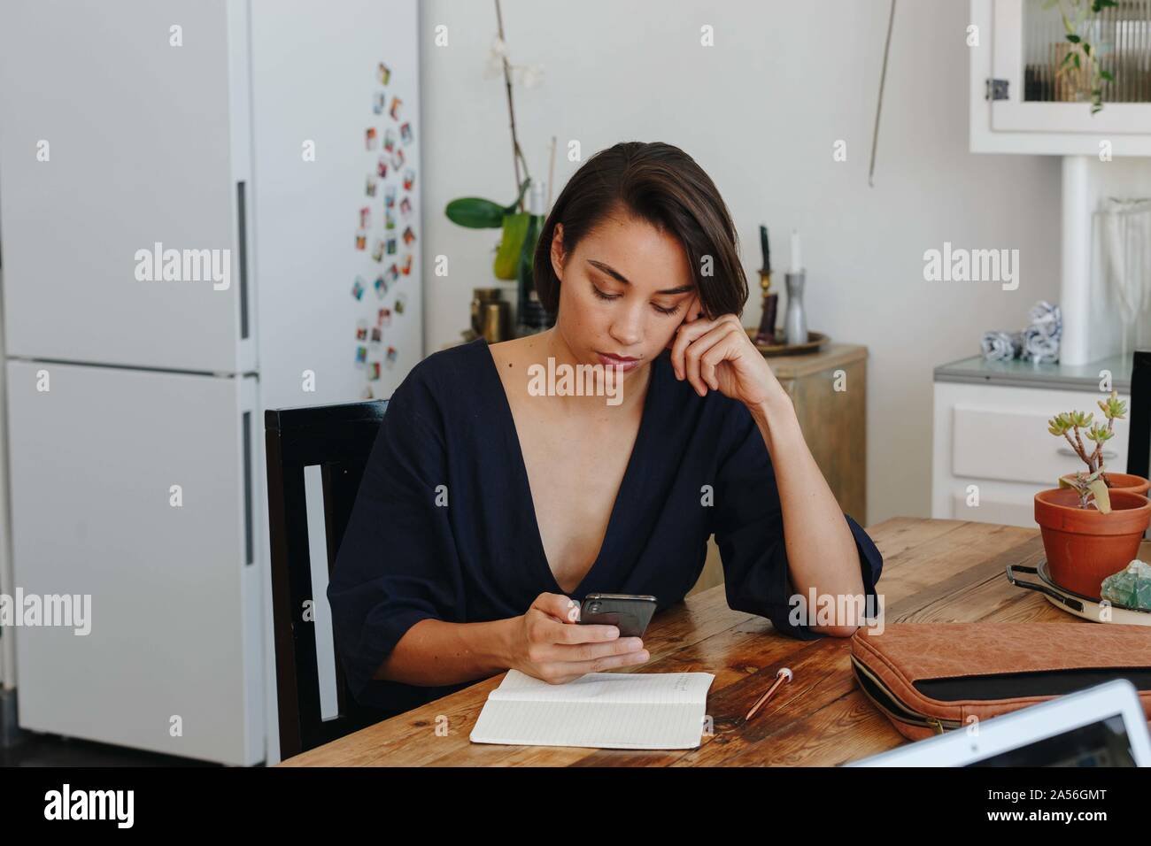 Businesswoman using cellular phone in office Stock Photo
